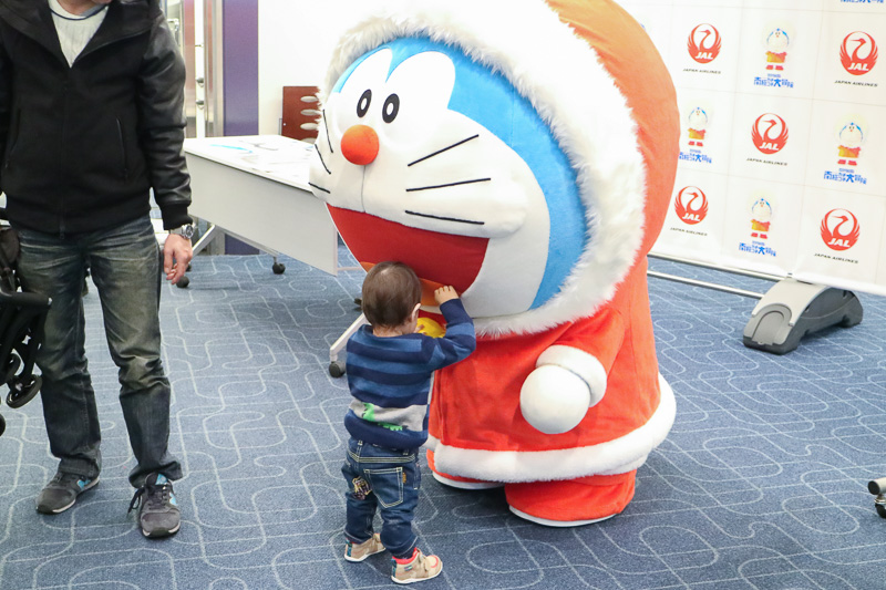 JAL ドラえもんJET」の国内線初便で、コート姿のドラえもんが出発