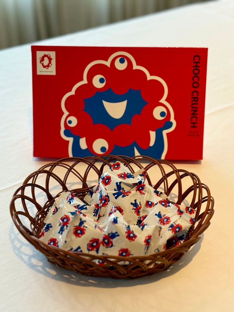 JAL、関空発の国際線でミャクミャクの袋入りチョコクランチを提供中